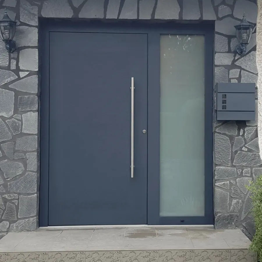 Anthrazitfarbene Aluminium-Haustür mit Glasseitenteil in einer Natursteinwand