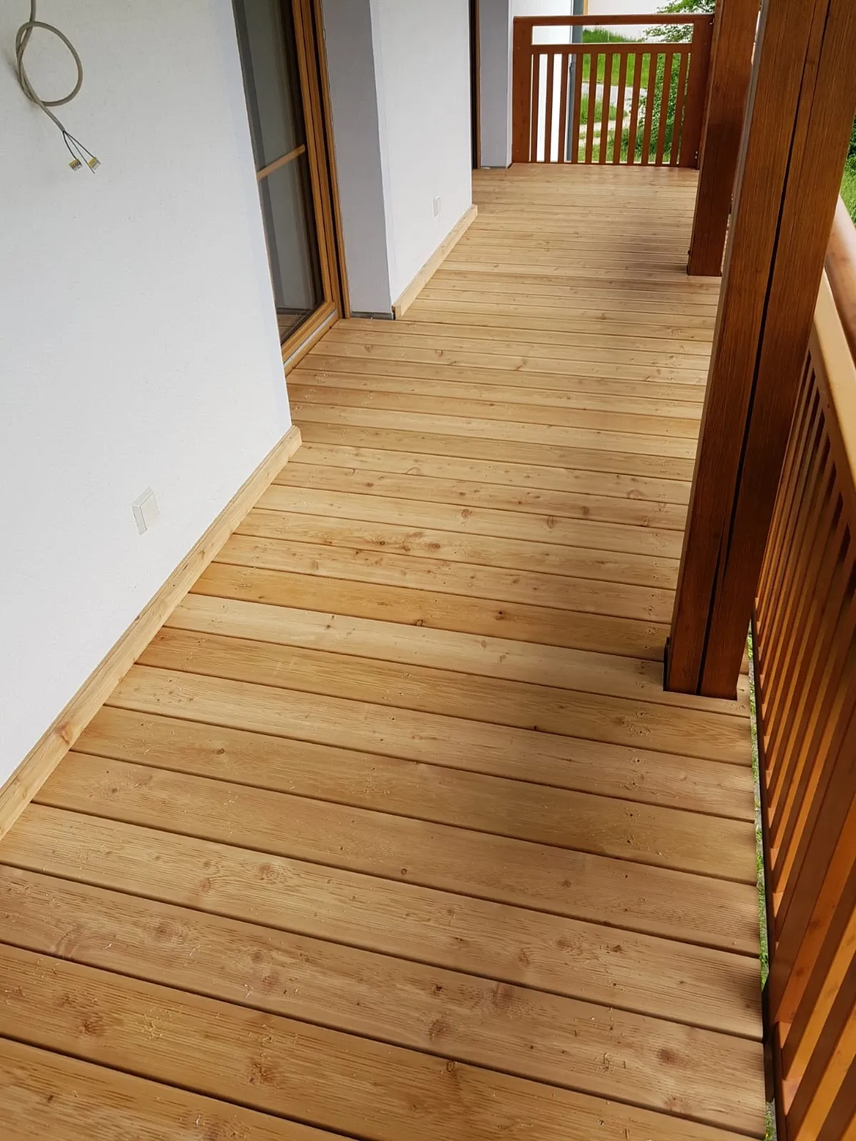 Balkon mit neu verlegten Lärchendielen und Holzgeländer