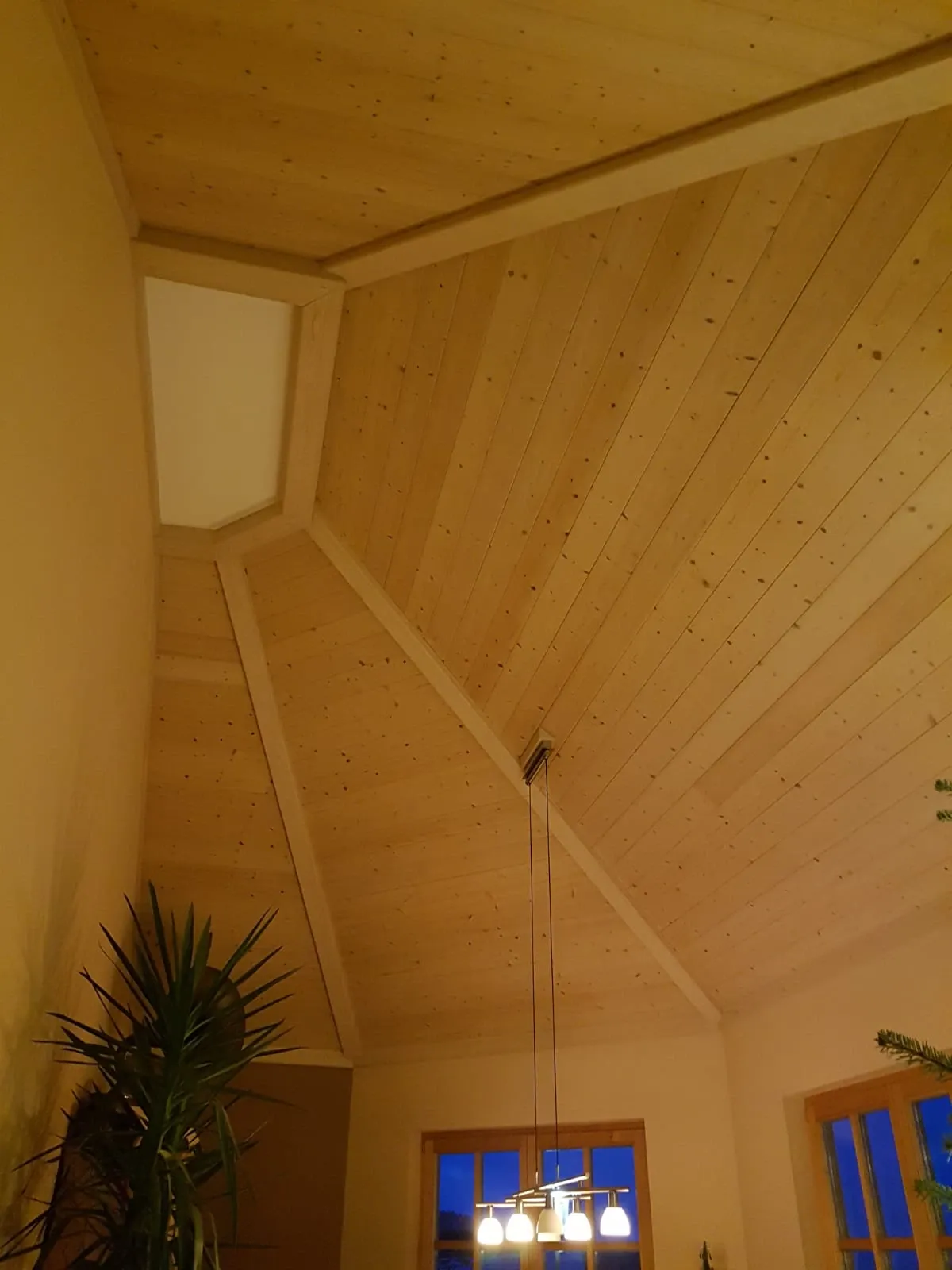 Hohe, schräge Wohnzimmerdecke mit Fichtenholz verkleidet